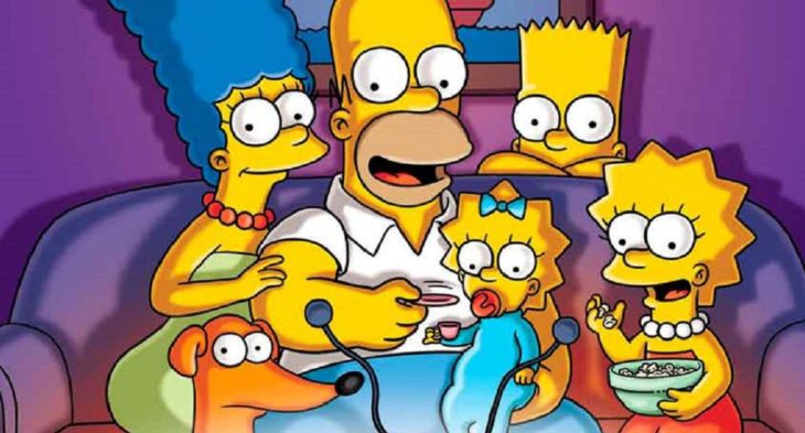 Personajes de la serie Los Simpson viendo la televisión en la sala de su casa 