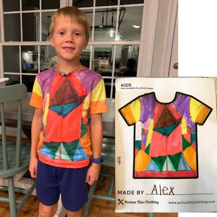 Niño posando una camisa que previamente diseño y coloreo 