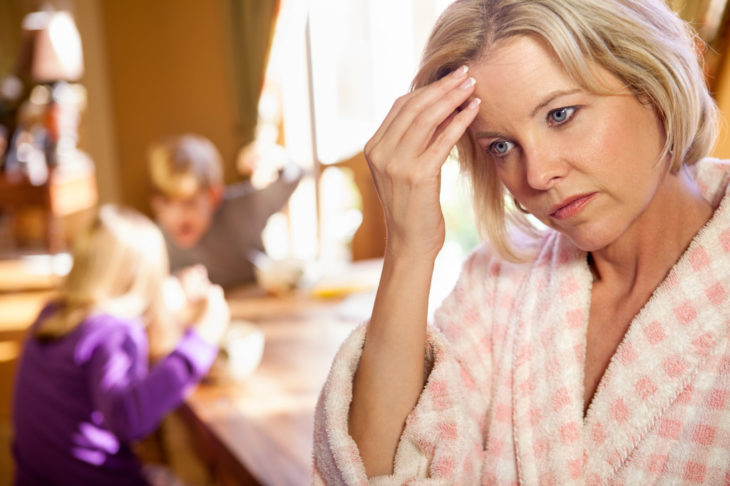 Donna che guarda frustrata mentre i suoi figli combattono