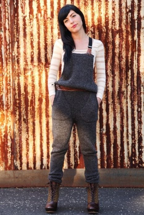Chica usando un overol de lana de color gris y botas militares mientras está posando para una foto 