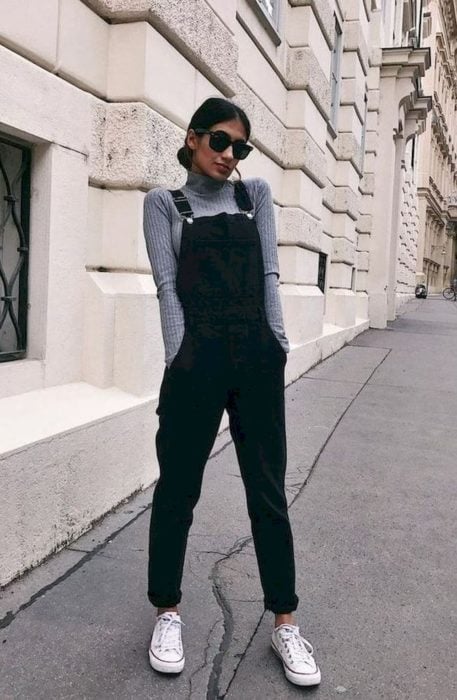 Chica usando un overol de color negro con una blusa de color gris 