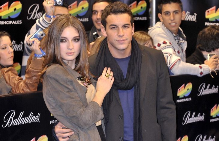 Mario Casas y María Valverde abrazados mientras están en la alfombra roja de los 40 principales 