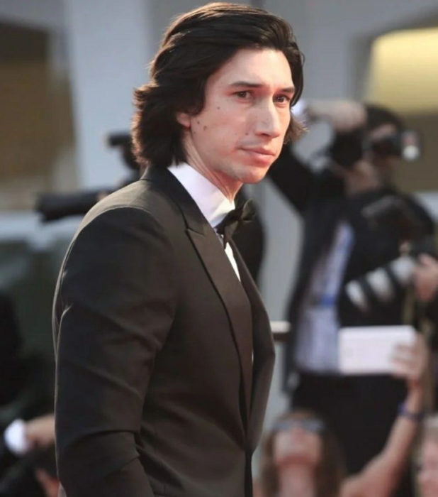 Actor Adam Driver; hombre de traje negro, cabello oscuro y largo