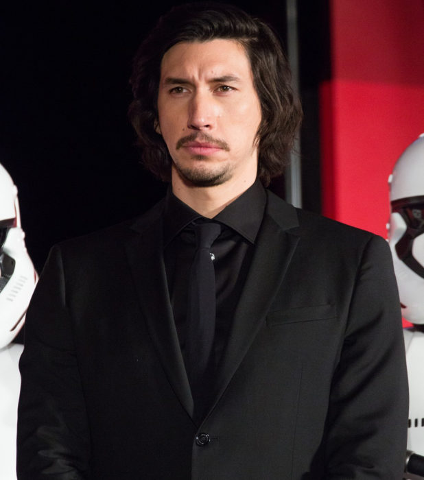 Actor Adam Driver; hombre serio de cabello largo con traje negro