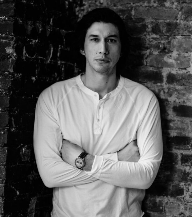 Actor Adam Driver; fotografía en blanco y negro de hombre de ojos negros, cabello oscuro con los brazos cruzados