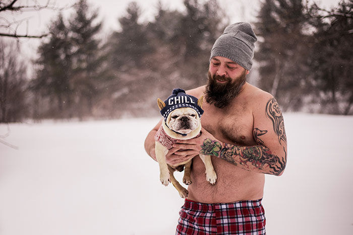Hombre posando junto a un perrito bulldog durante una sesión de fotos para un calendario
