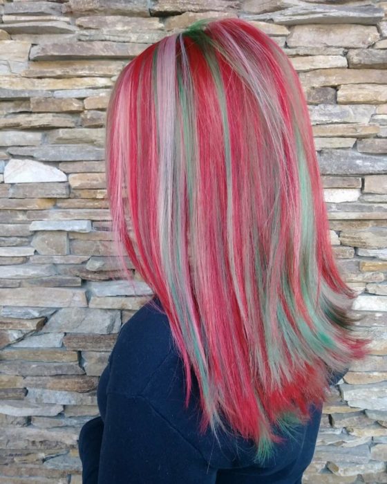 Chica con el cabello teñido de color rojo con azul y luces en tonos platinados 