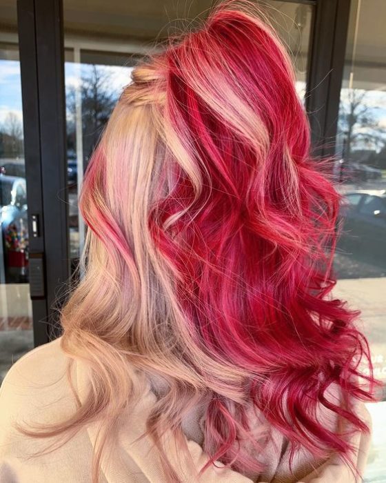 Chica con el cabello teñido de color caramelo con tintes rubios y rojos