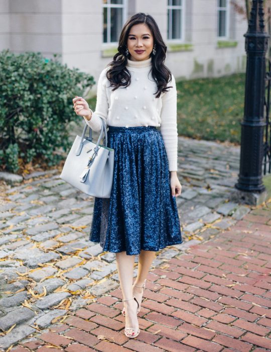 Pantone elije el classic blue como el color del 2020; mujer con falda azul clásico de terciopelo, blusa blanca y bolsa grande de mano