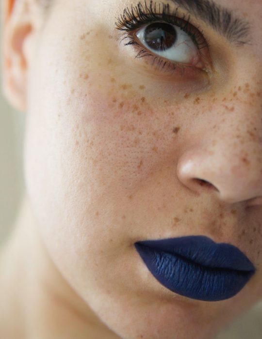 Pantone elije el classic blue como el color del 2020; mujer con pecas y labios pintados de azul clásico