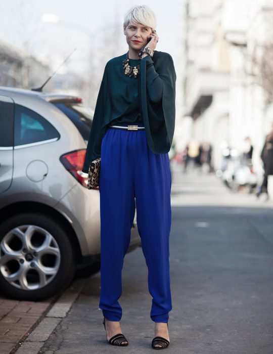 Pantone elije el classic blue como el color del 2020; chica de cabello pixie, color blanco, con blusa de mangas holgadas verde y pantalones azul clásico, bolsa de mano de animal print, chica hablando por celular