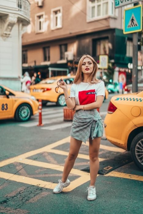 Chica caminando entre una avenida transitada de nueva york