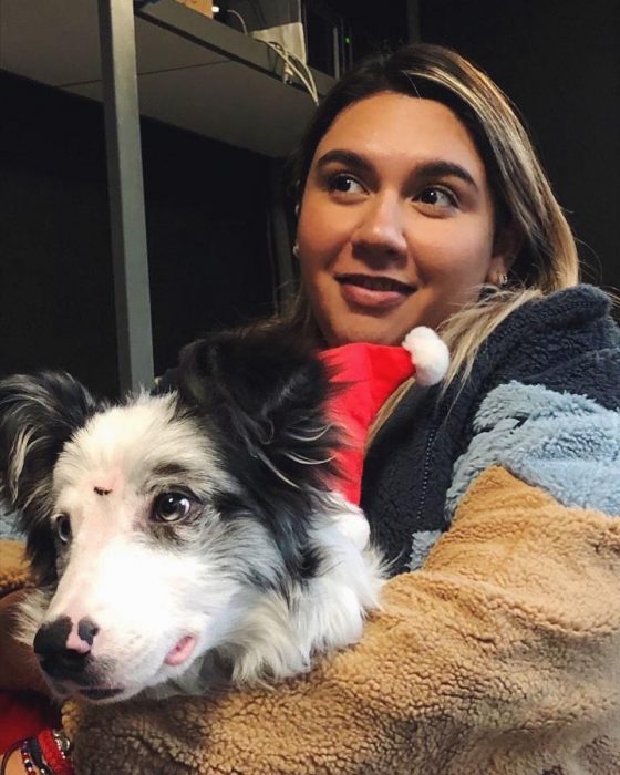 Chica abrazando un perro pastor entre sus brazos