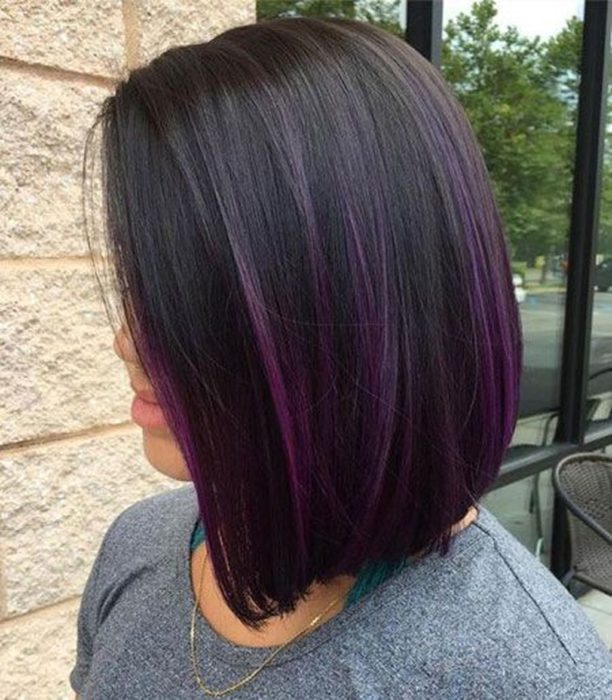 Chica mostrando su cabello de color dark violeta con un corte bob 