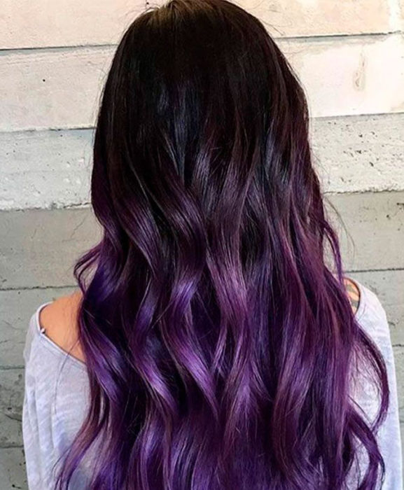 Chica con el cabello en tono dark violeta con luces en morado 