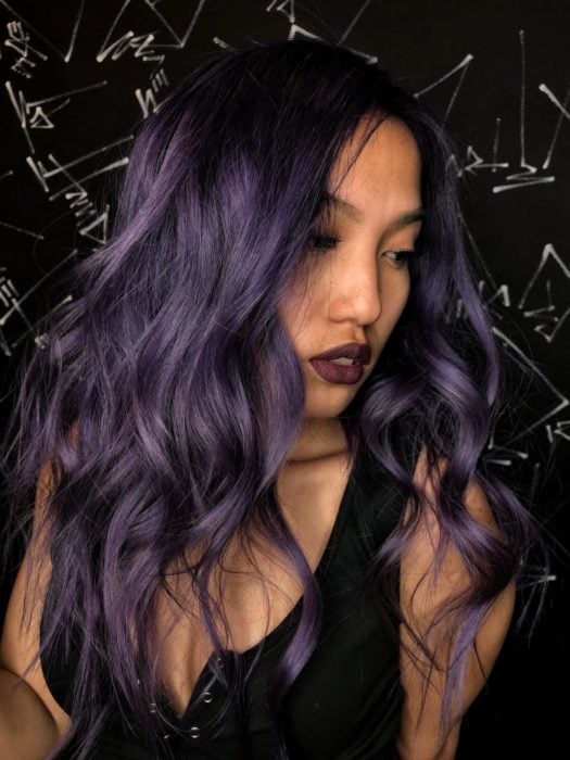 Chica mostrando su cabello de color dark violeta con destellos de platinado 