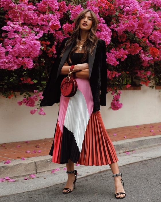 chica con chamarra negra y falda plisada de colores