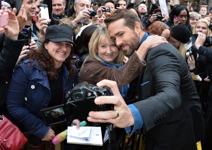 Ryan Reynolds sosteniendo una cámara para tomar una selfie con sus fans