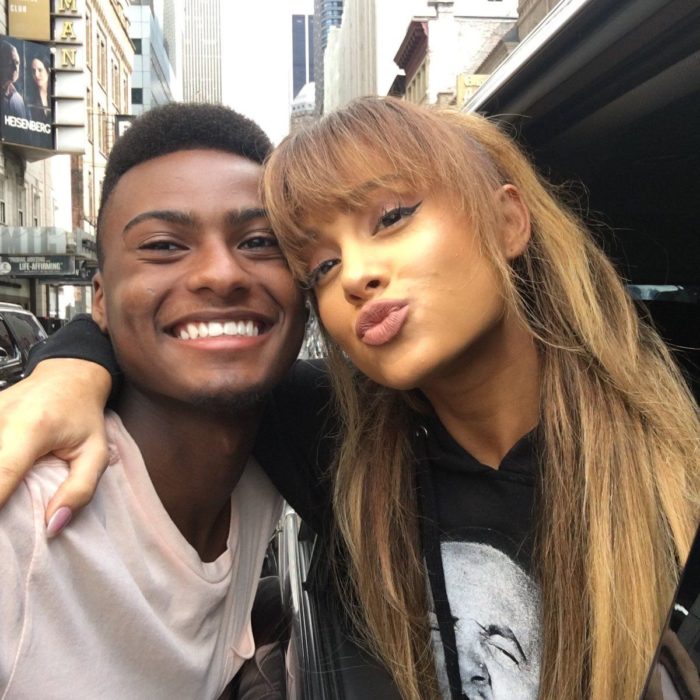 Ariana Grande abrazada de un chico tomando una selfie 