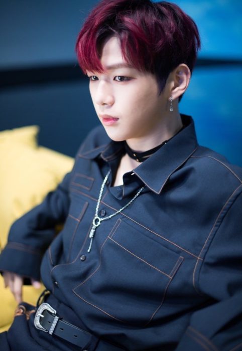 Kang Daniel sentado en una silla posando para una fotografía