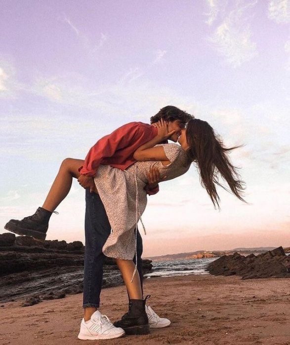 Pareja se besa feliz en la playa