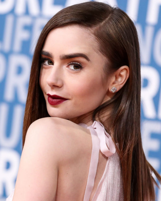 Peinados de Lily Collins para Año Nuevo; mujer con maquillaje natural, cabello castaño, lacio y largo suelto