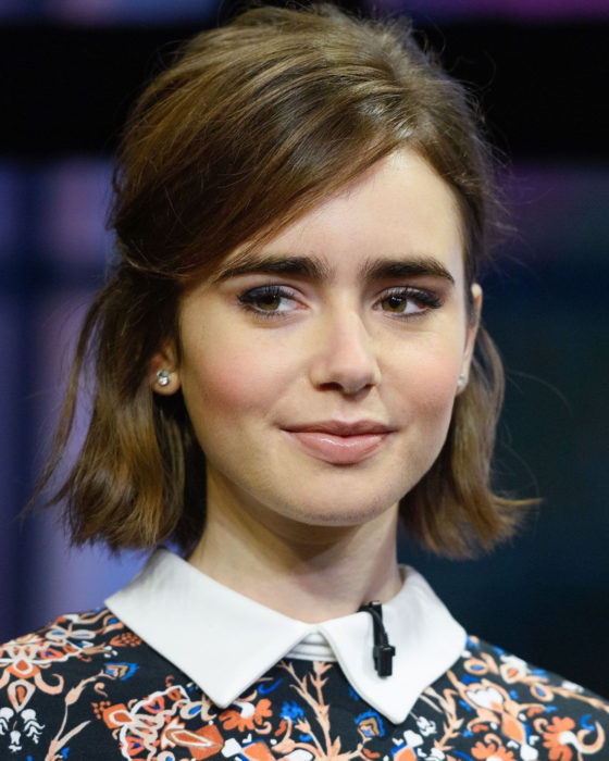 Peinados de Lily Collins para Año Nuevo; mujer de cabello corto, arriba de los hombros, lacio, castaño, con media coleta