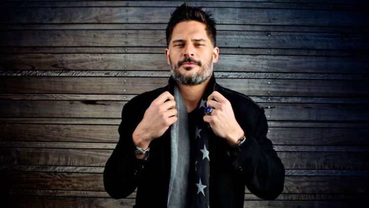 Joe Manganiello sosteniendo su chaqueta para tomar una fotografía