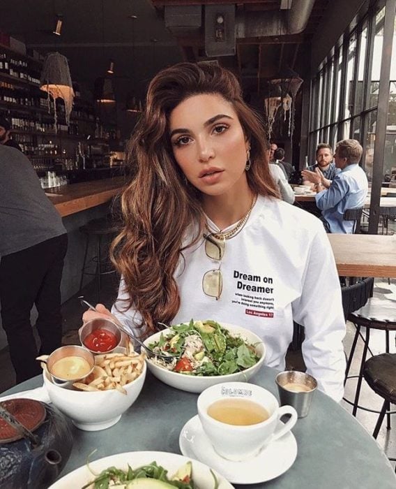 Chica comiendo en restaurante 