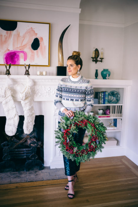 Chica usando un ugly sweter de color gris con blanco y falda de color con brillos 