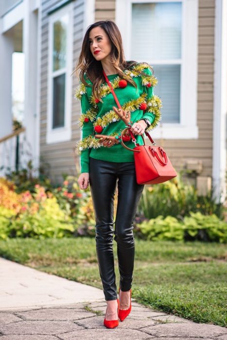 Chica usando un ugly sweter de color verde con unos leggins de color negro 