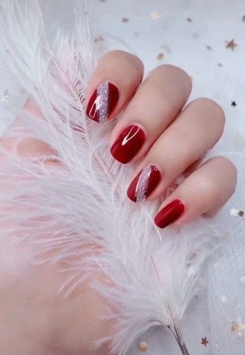 Manicura en rojo con detalle plateado en glitter