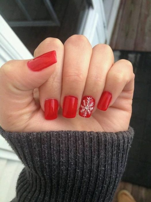 Manicura en rojo con un copo de nieve en blanco