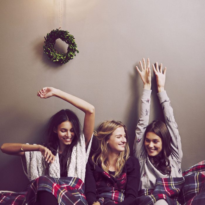 Primas reunidas en Navidad; amigas cobijadas sonriendo