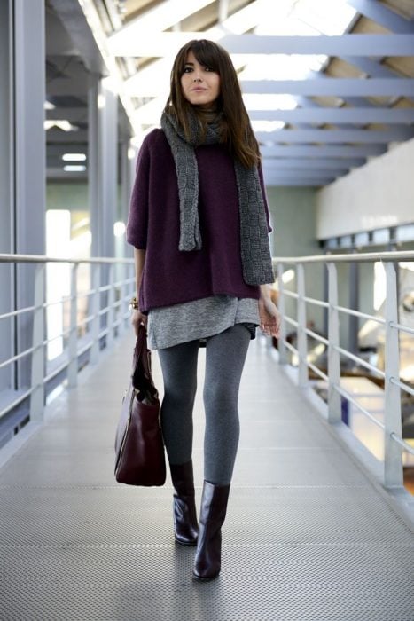 Chica caminando mientras usa un abrigo de color guinda, bufanda y medias de lana en color gris con botines 