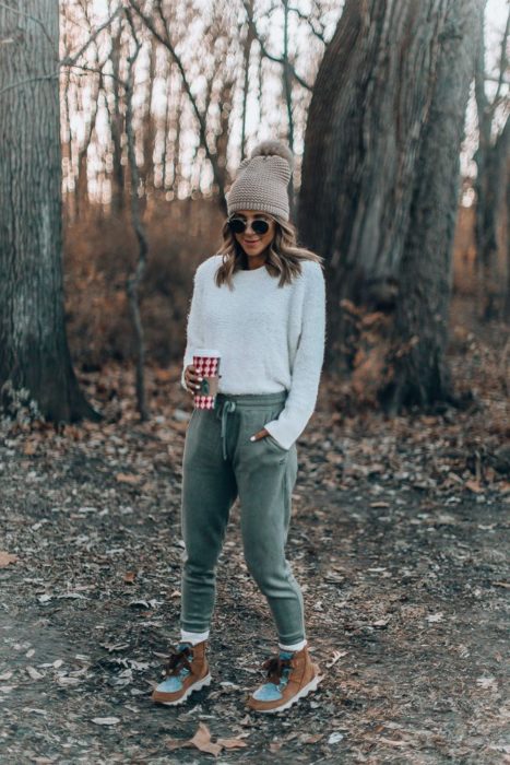 Chica usando un pants de color verde con un blusón de color beige 