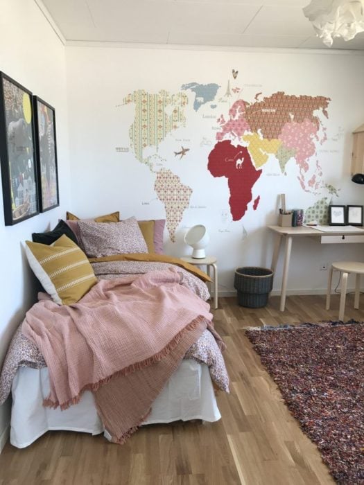 Habitación de chica decorada con mapas y cuadros