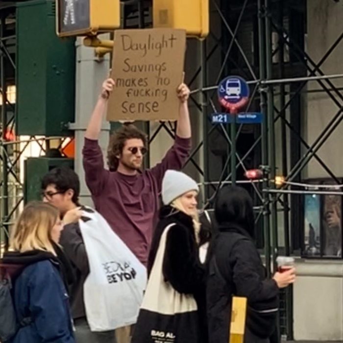 Chico con una pancarta protestando por el horario de verano en las calles de Nueva York 