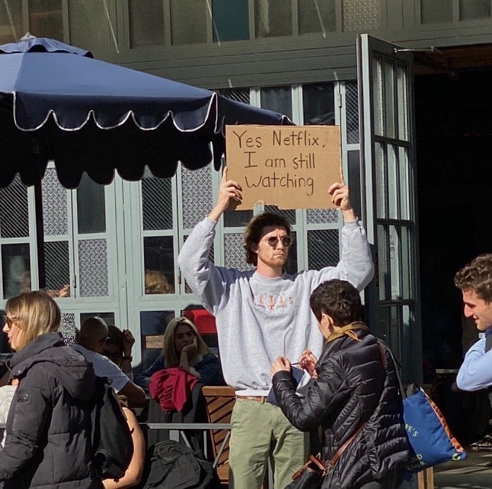 Chico con una pancarta en la que protesta en contra de Netflix
