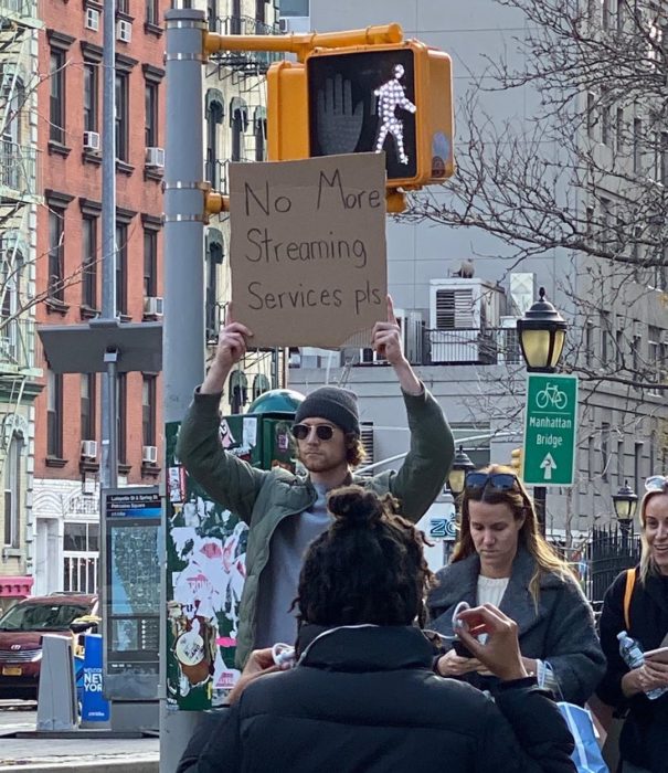 Chico levantando un cartel con una protesta en contra del servicio de streamign