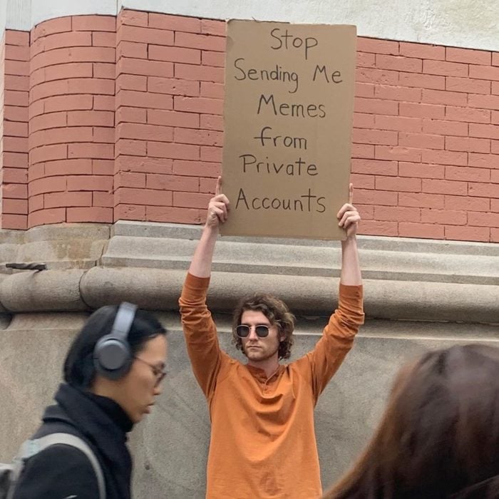 Chico con una pancarta protestando por enviar memes de cuentas privadas 