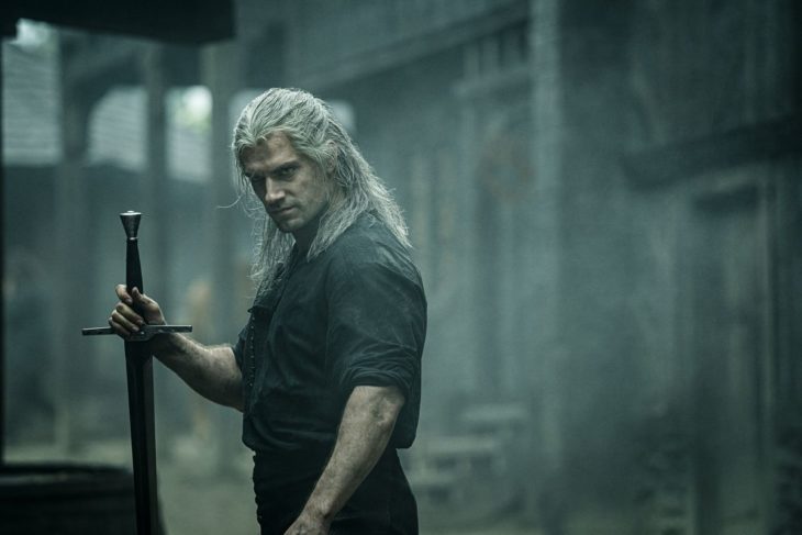 Henry Cavill como Geralt de Rivia en The Witcher sosteniendo una espada