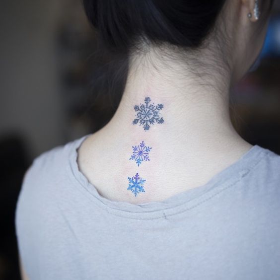 Chica de espaldas mostrando sus tatuajes de copos de nieve