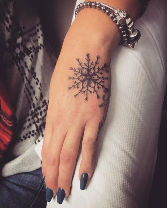 Tatuaje de copo de nieve gigante en la mano