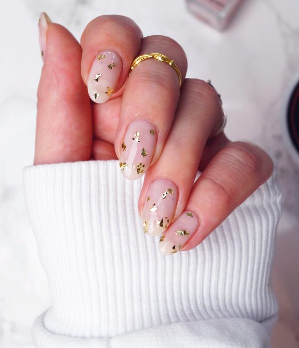 Manicure con detalles dorados para la fiesta de Año Nuevo; uñas largas en forma de almendra