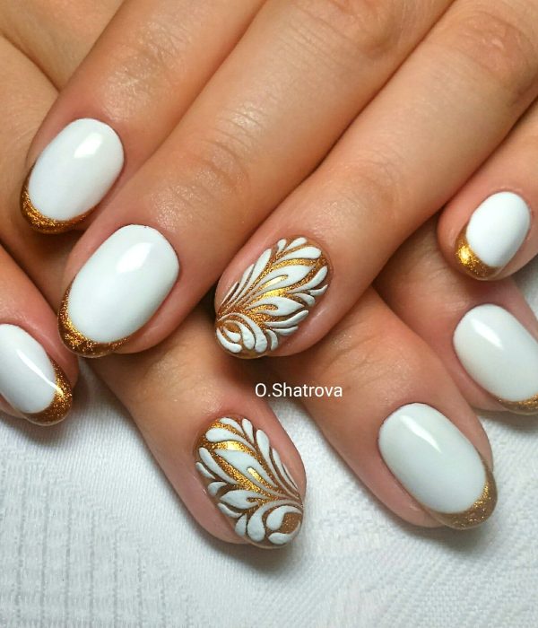 Manicure blanco con dorado para la fiesta de Año Nuevo; uñas cortas en forma de almendra