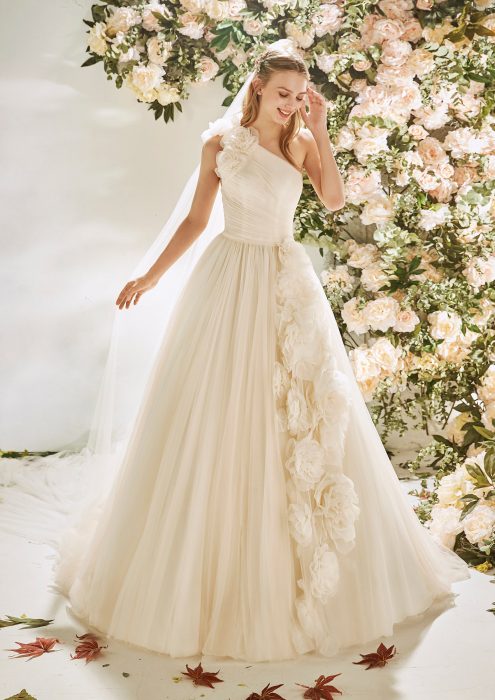 Chica con un vestido de novia en color blanco con flores en la parte de la falda 