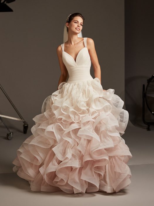 Ragazza in abito da sposa in colori sfumati con in rosa con diversi strati di tulle 