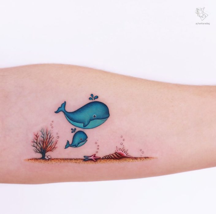 tatuaje colorido de una ballena junto a su bebé 