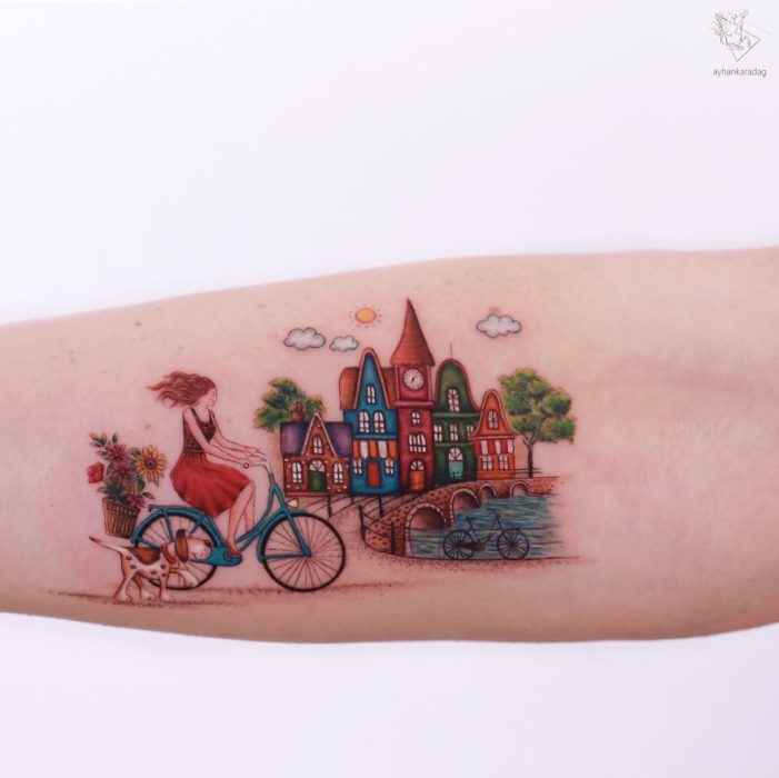 Tatuaje de una chica que recorre un pueblo en bicicleta 